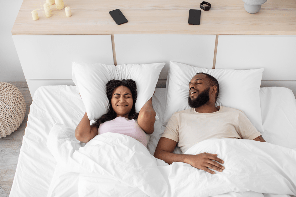 Couple in bed facing emotional challenges in a New York marriage, with one partner experiencing anger due to adult ADHD and the other attempting to disengage, highlighting the need for effective communication and understanding.