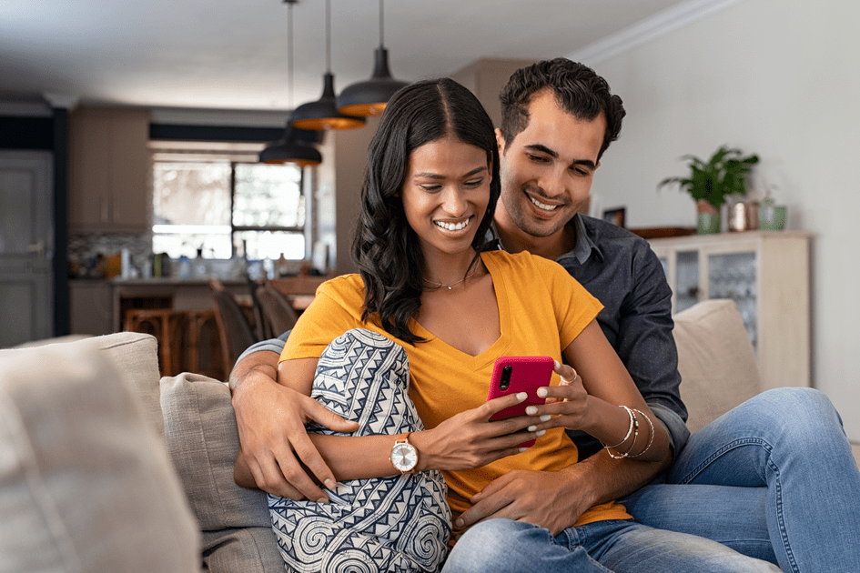 Couple embracing on couch during an online couples therapy session at Loving at Your Best in New York City, seeking support and guidance to manage adult ADHD in their relationship, nurturing trust and communication.