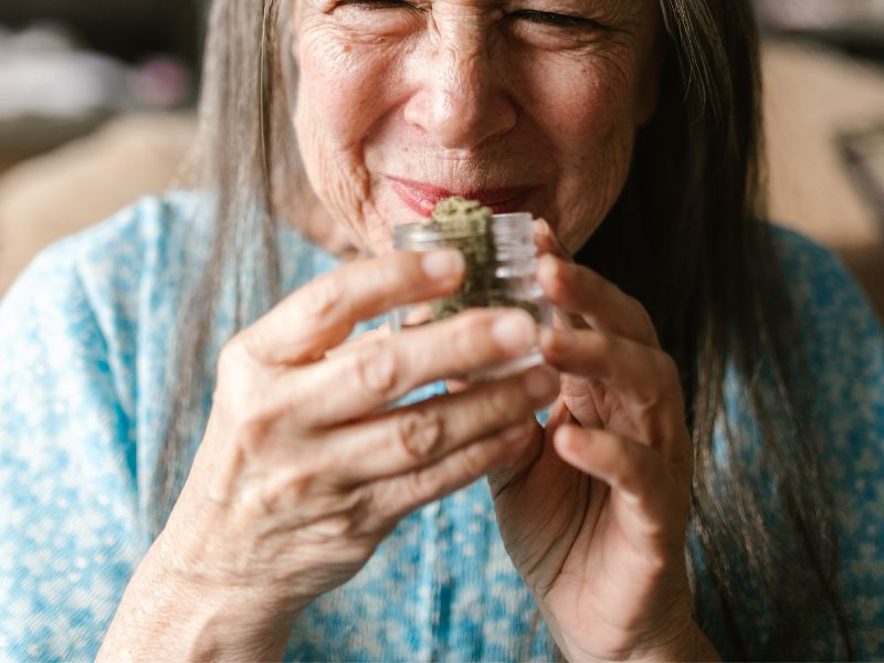 woman smelling cannabis jar