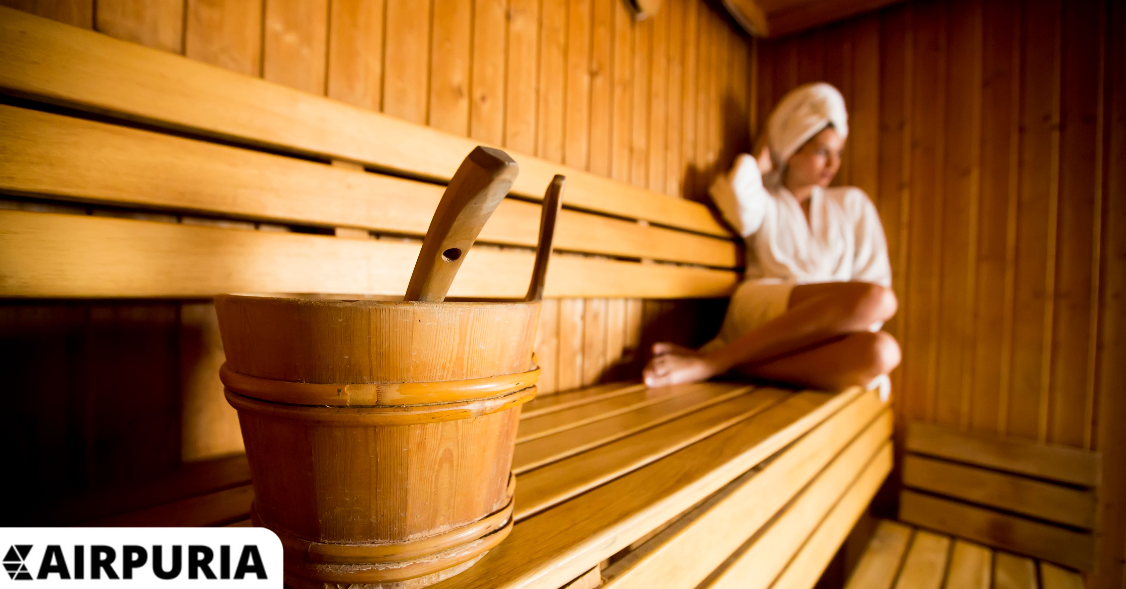 Image of a woman in a sauna thinking about the things to consider when choosing an infrared sauna OR a traditional sauna.