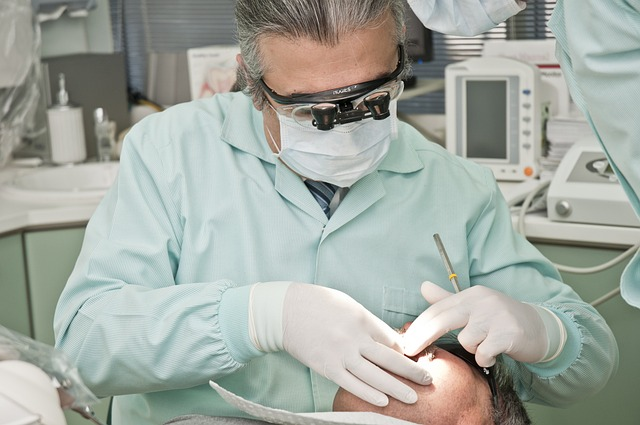 An image of a dentist examining a patient's teeth and mouth.