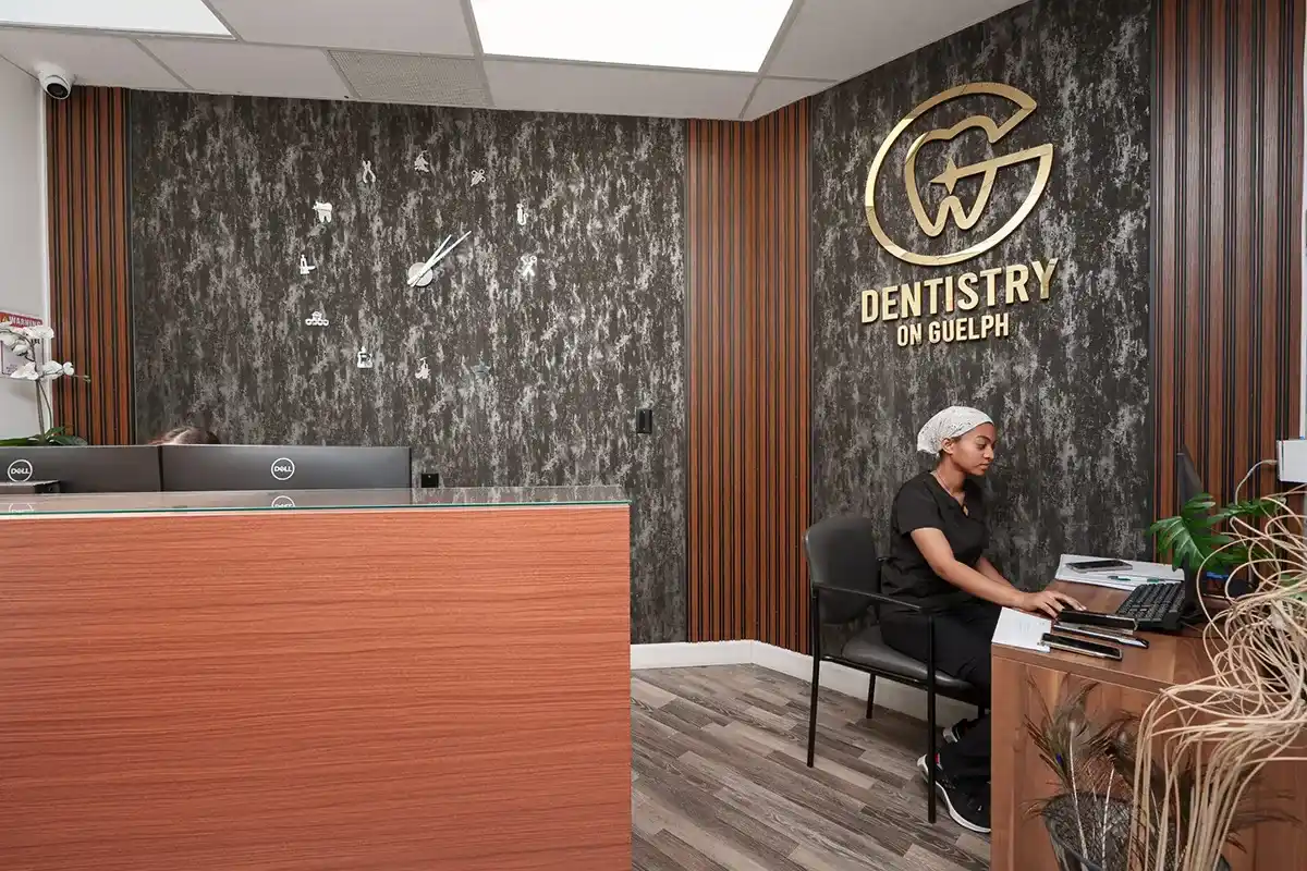 Modern reception area of Dentistry on Guelph featuring contemporary design, branded wall signage, and a professional office staff providing administrative support.