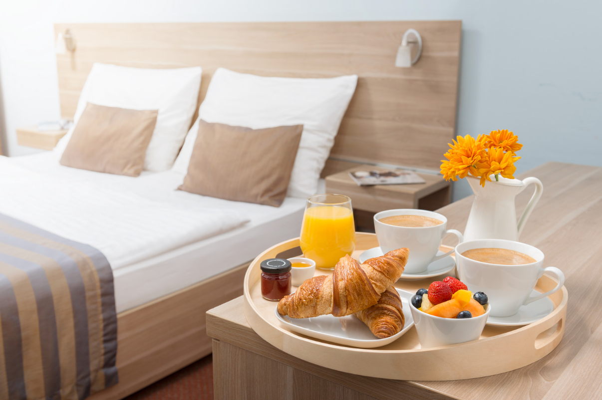 Breakfast sitting next to hotel bed