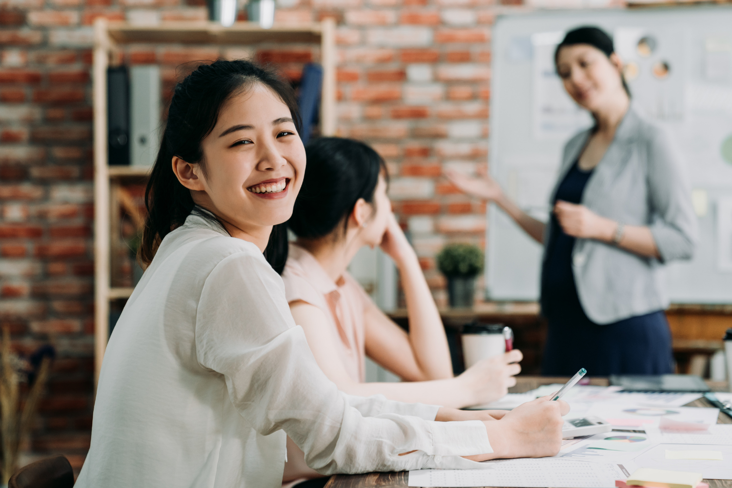An office scene with Filipino coworkers smiling.