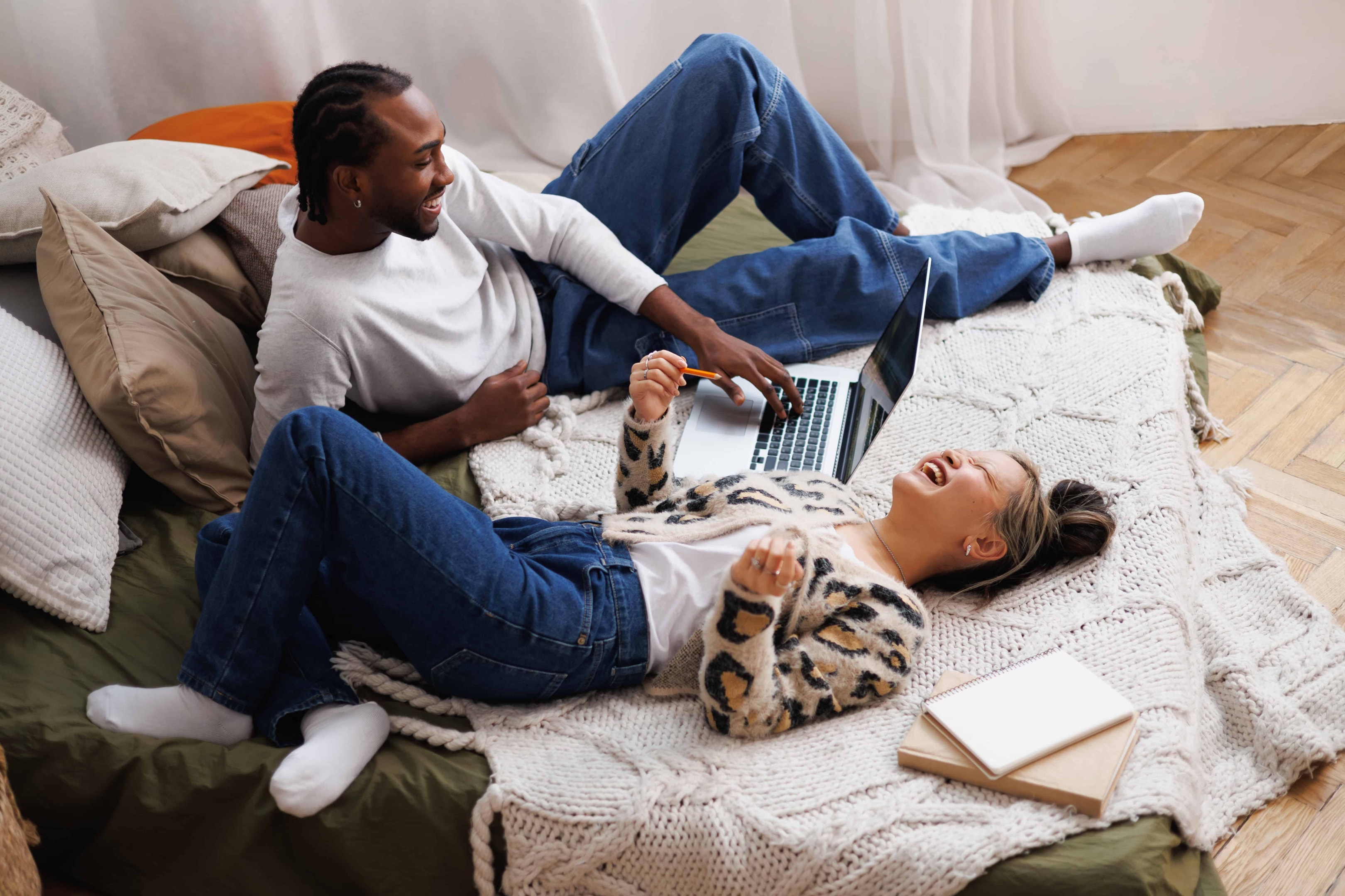 Couple in bed with a laptop, creating a plan together.