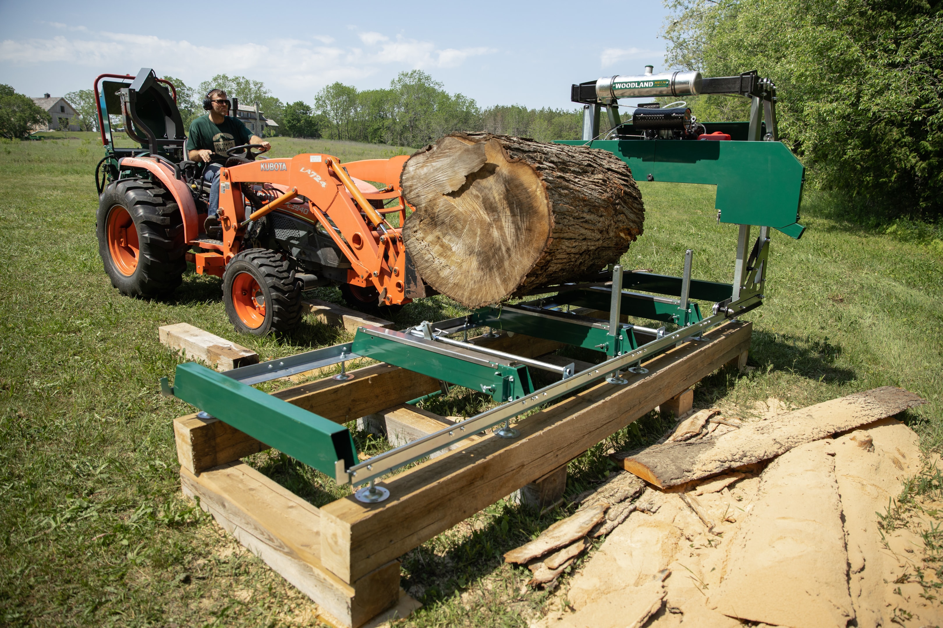 A fork loader unloading a log onto a bandsaw mill.