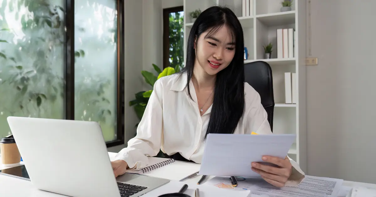Woman reviewing tax records and making notes on how long to retain tax returns for her business.