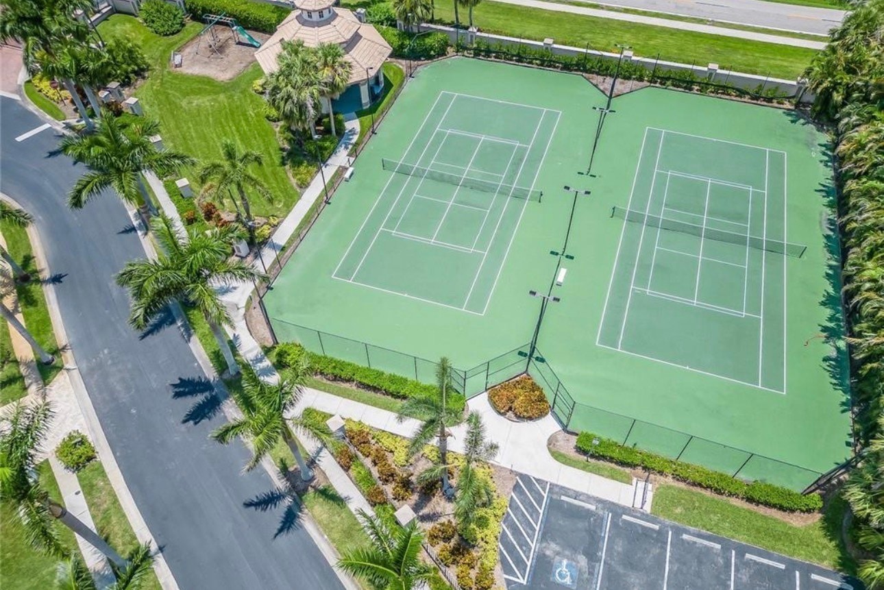 An aerial view showcases upscale waterfront homes in a boating community, featuring private boat docks along a deep water access canal, perfect for boating enthusiasts. This picturesque scene highlights the beauty of Fort Myers and the tranquil lifestyle offered by Catalpa Cove real estate.