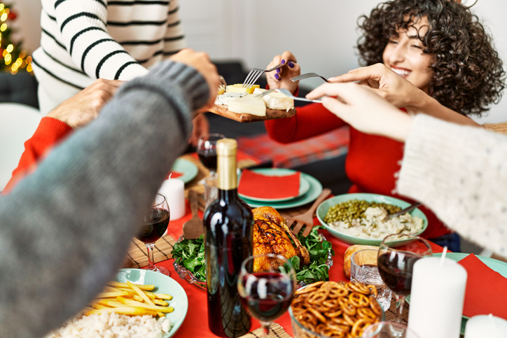 Happy friends enjoying a holiday potluck dinner. 