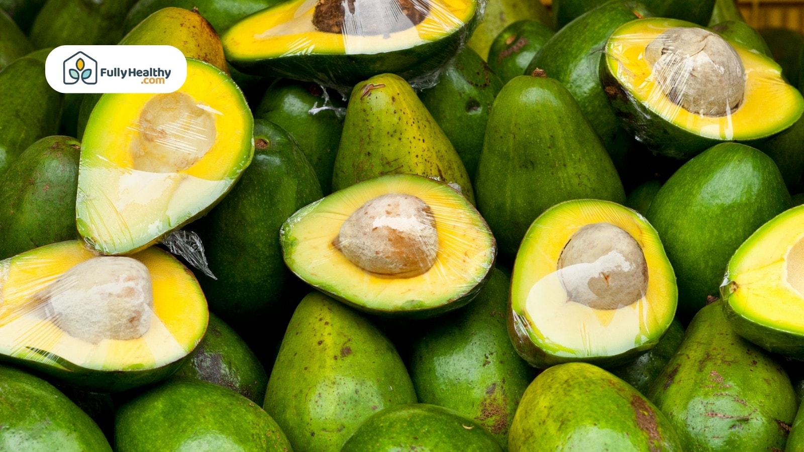 Fresh avocados with halved pieces wrapped in plastic for market display