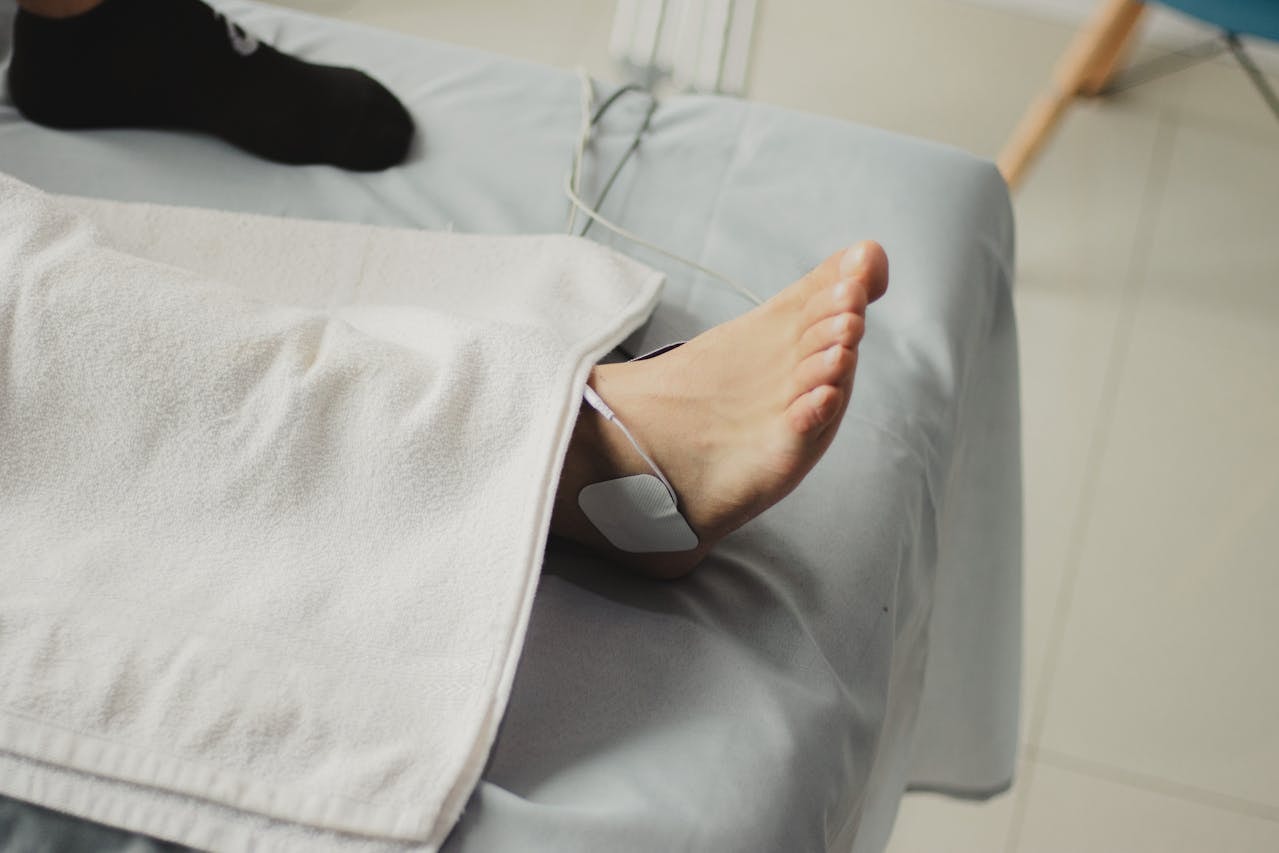 Patient resting with a treated foot on an exam table, showing conservative care and why is bunion surgery not recommended until symptoms affect daily walking and comfort.