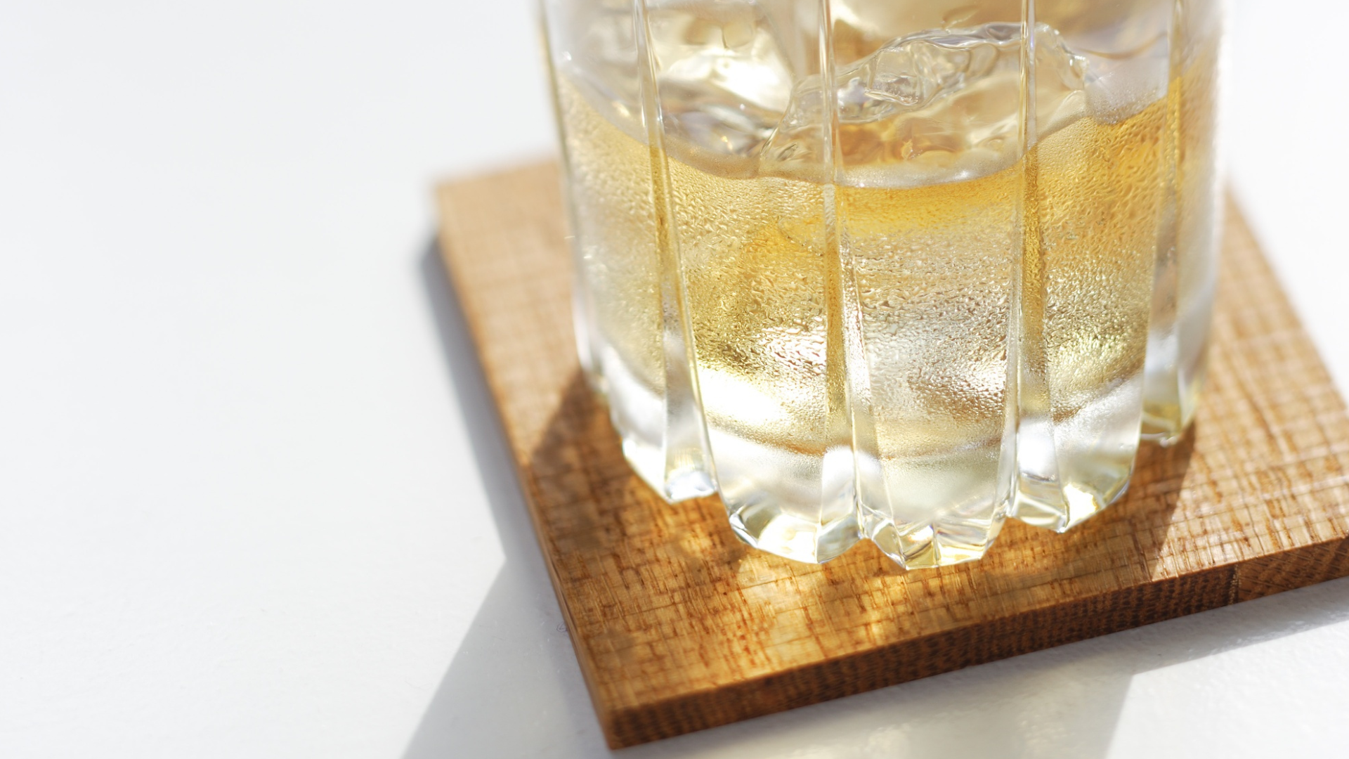 A thin sheet of wood being used as a coaster.