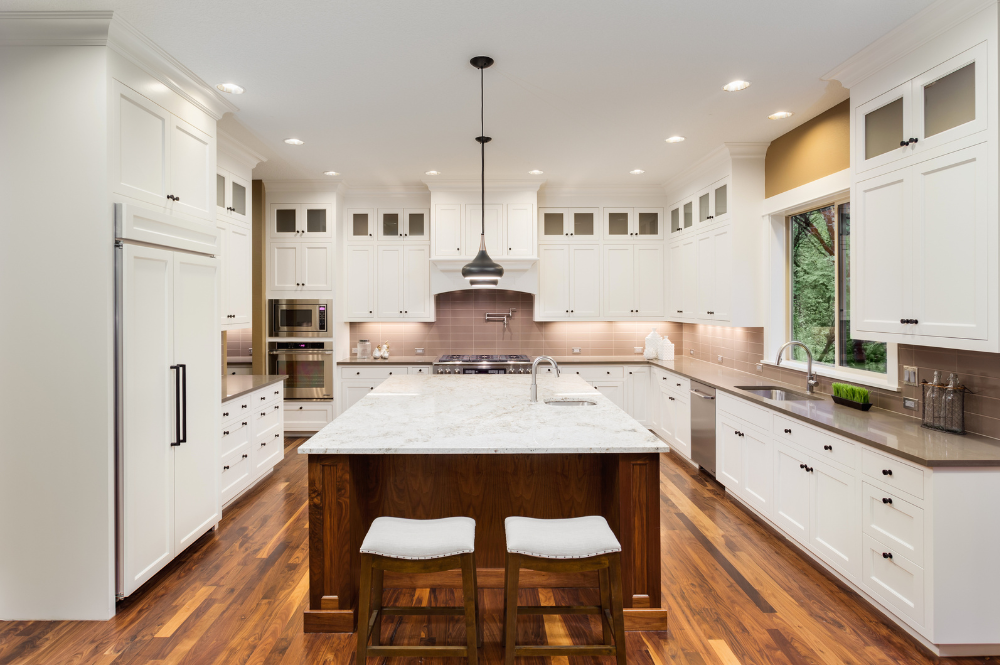 A spacious kitchen featuring white cabinets and hardwood floors, designed by a custom home architect in El Dorado Hills.