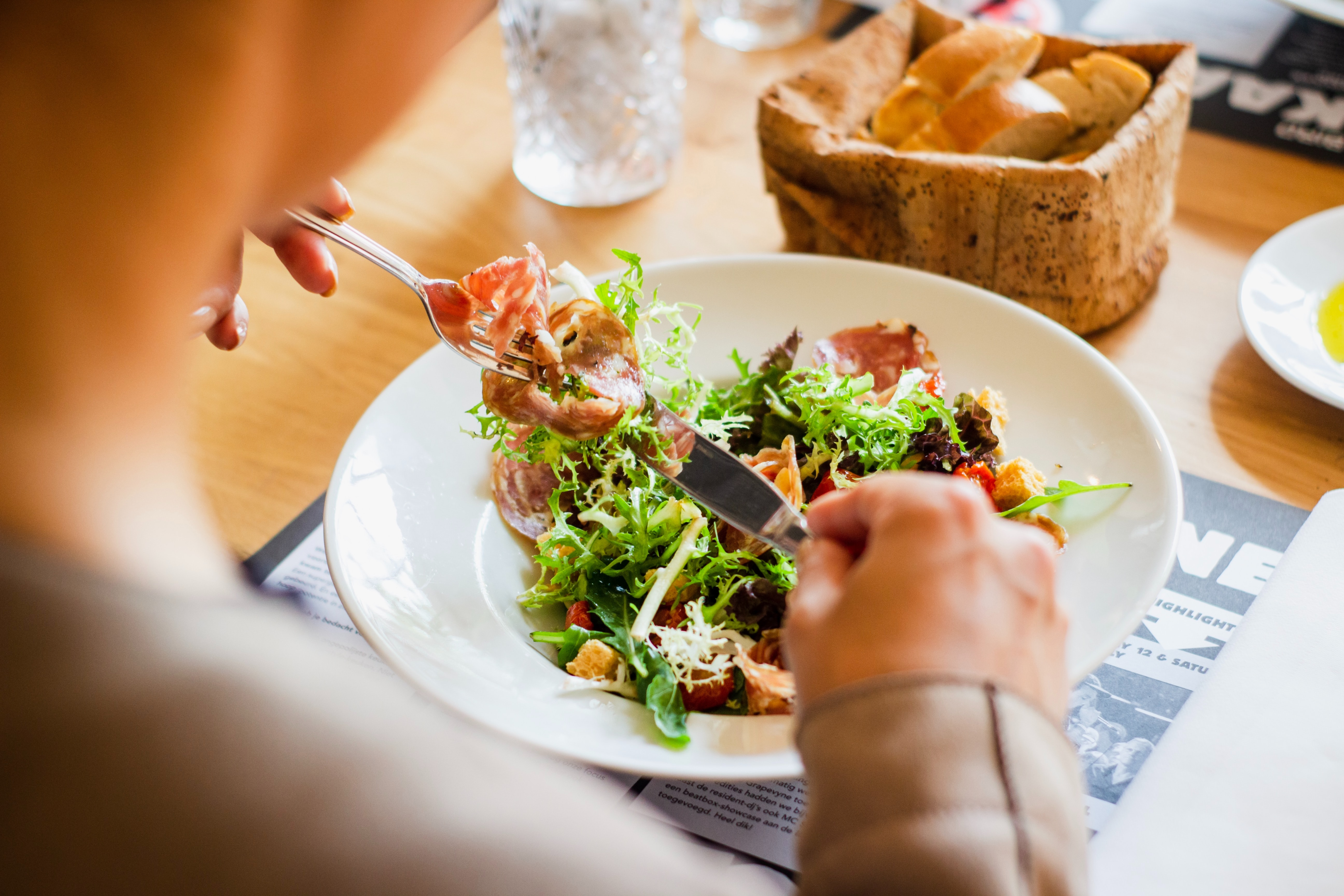 Um prato de salada sendo consumida por uma pessoa