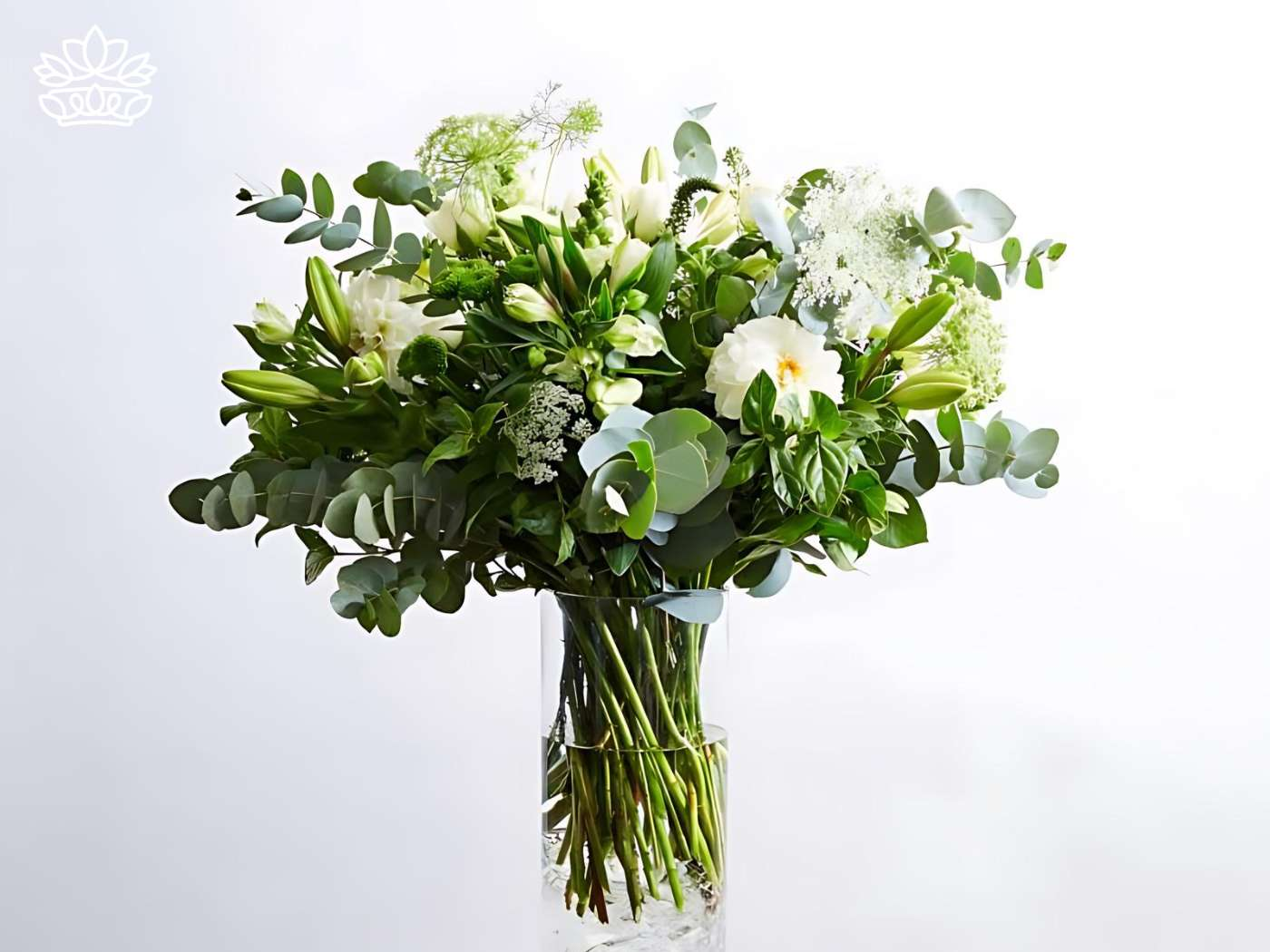 Elegant white floral arrangement in a glass vase featuring lilies, roses, and lush greenery, from Fabulous Flowers and Gifts.