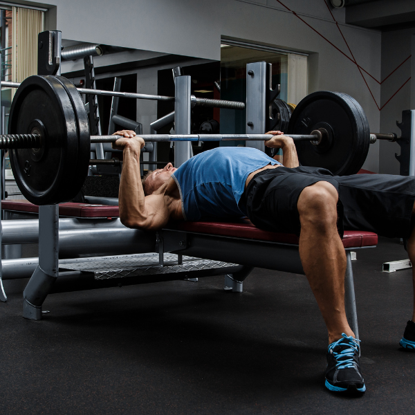 Image of a person performing the flat bench press exercise.