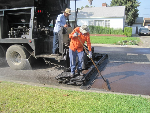 A slurry seal being applied to an existing pavement