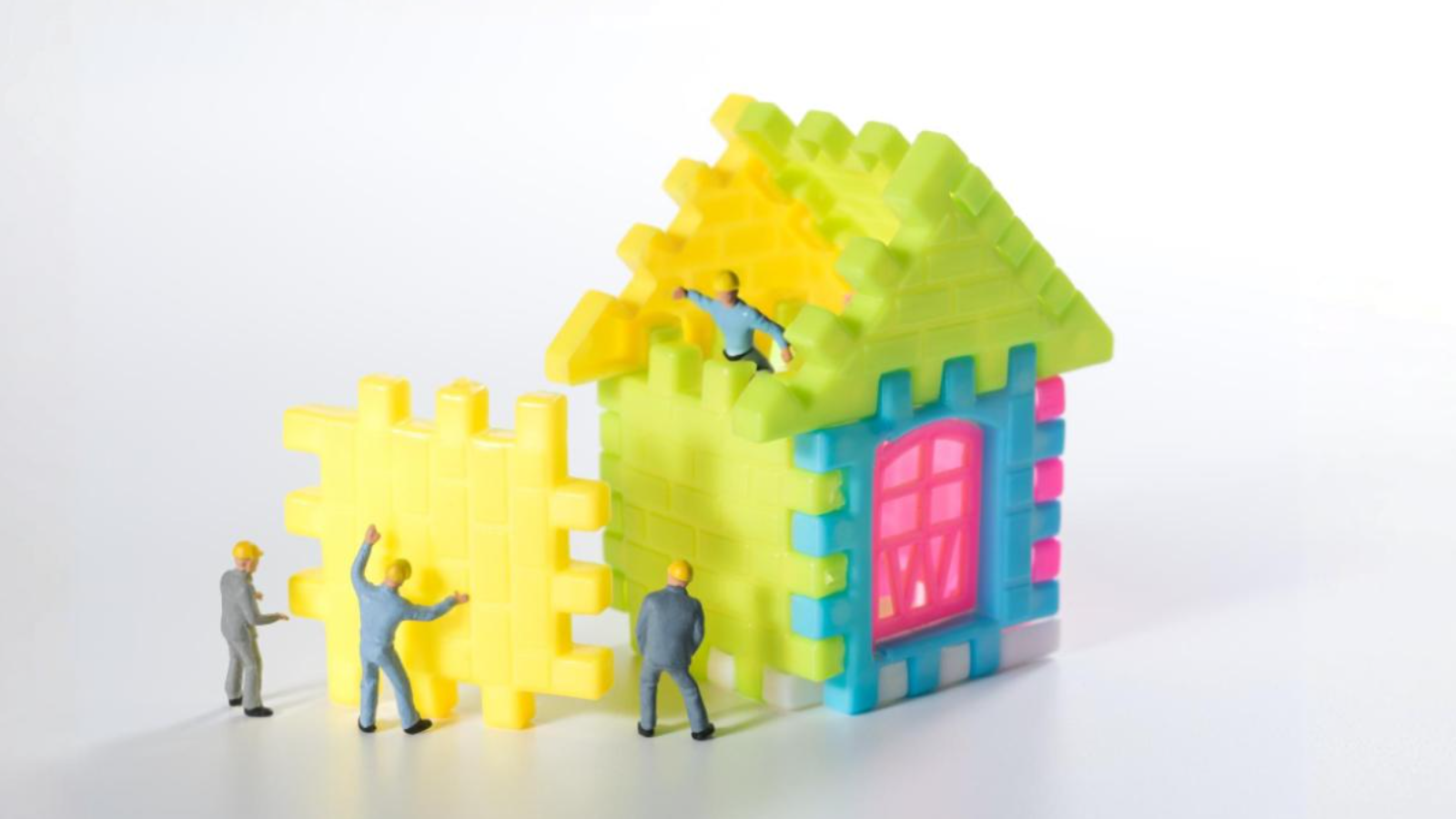 Figurines building a house. Conveying building a website that doesn't just look good but performs too. 