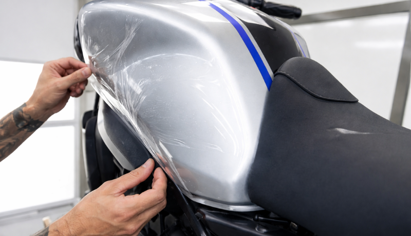 A man is wrapping PPF on the motorcycle.