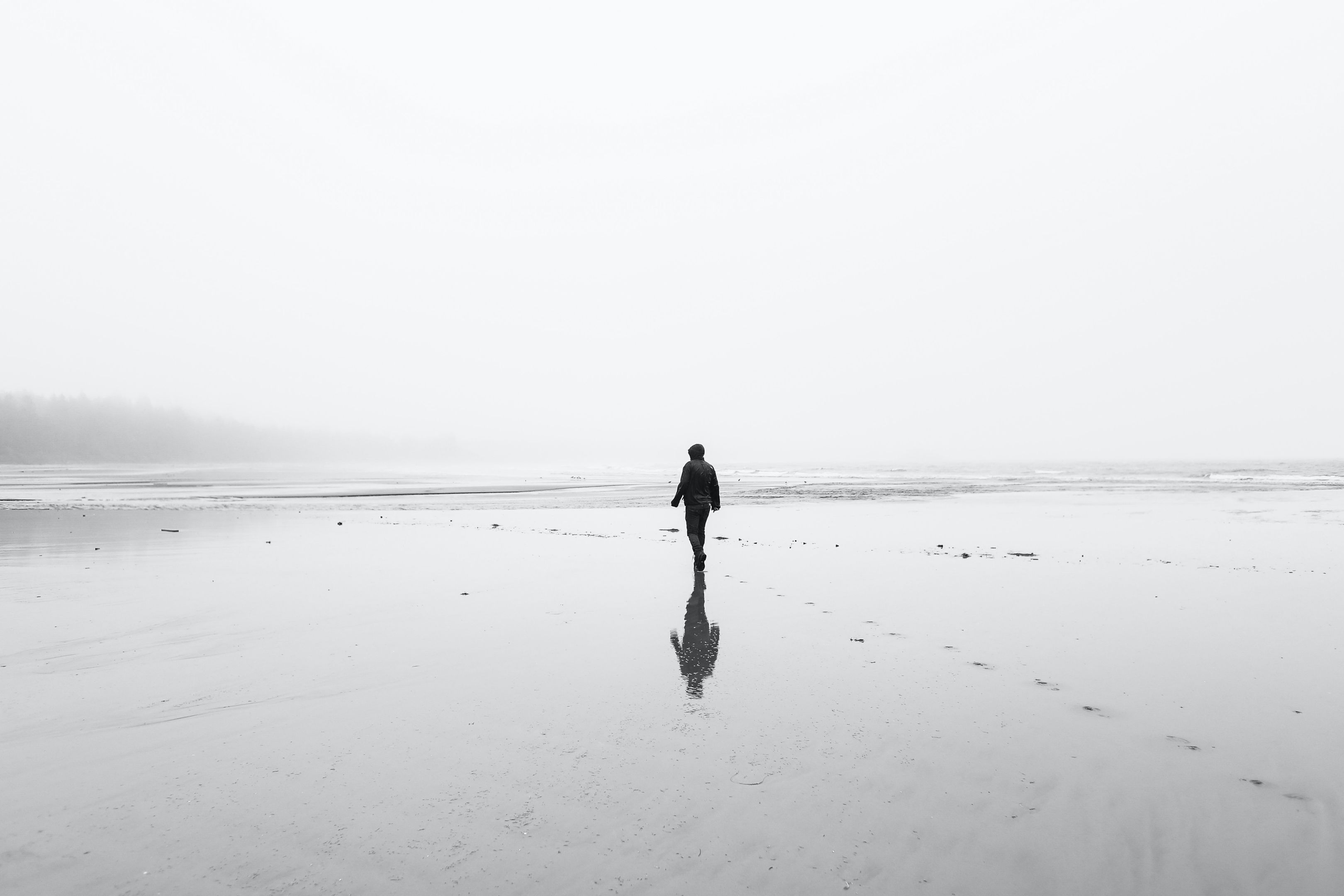 person walking on beach alone, black and white photo