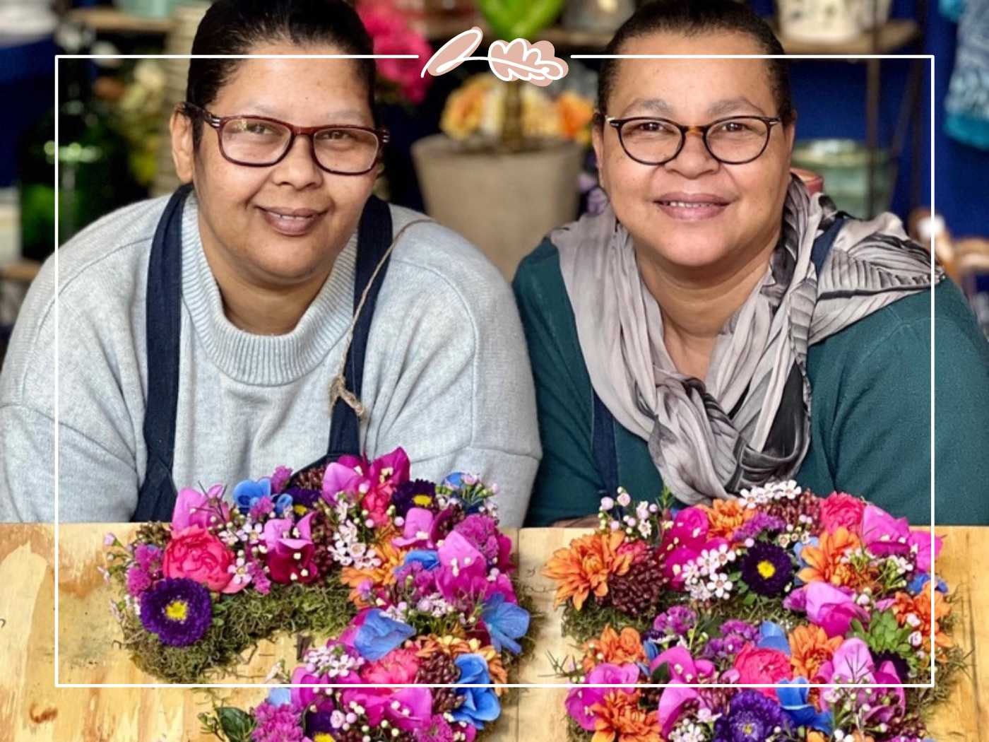 Two women smiling with colorful floral arrangements on the table - Fabulous Flowers and Gifts