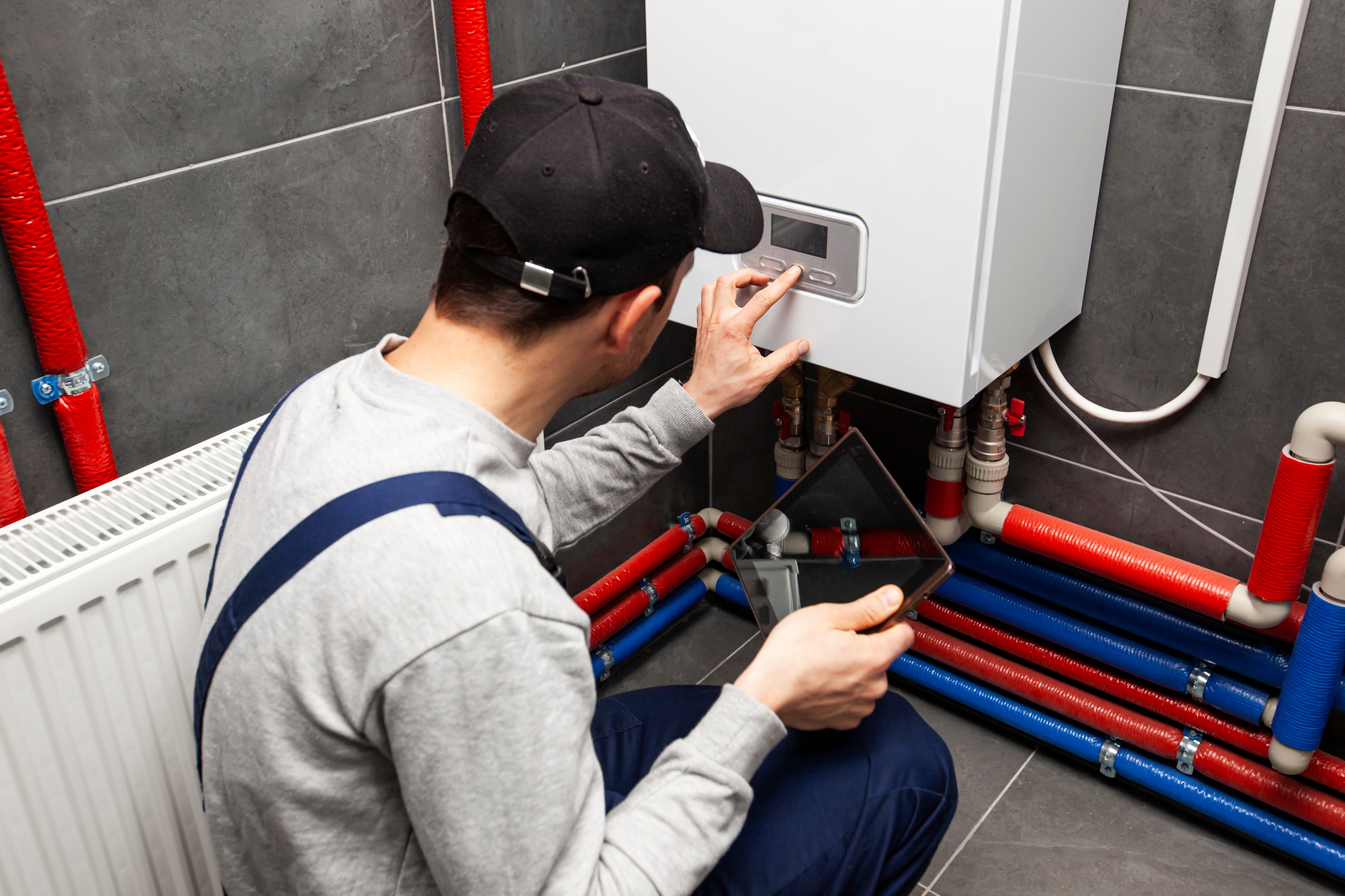 A maintenance technician performing regular checks on a heat pump to ensure less noise.