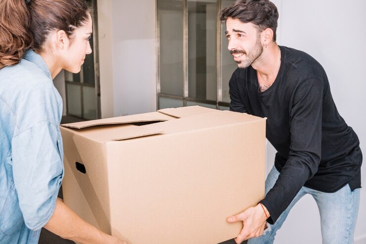 man helping a woman lift a box