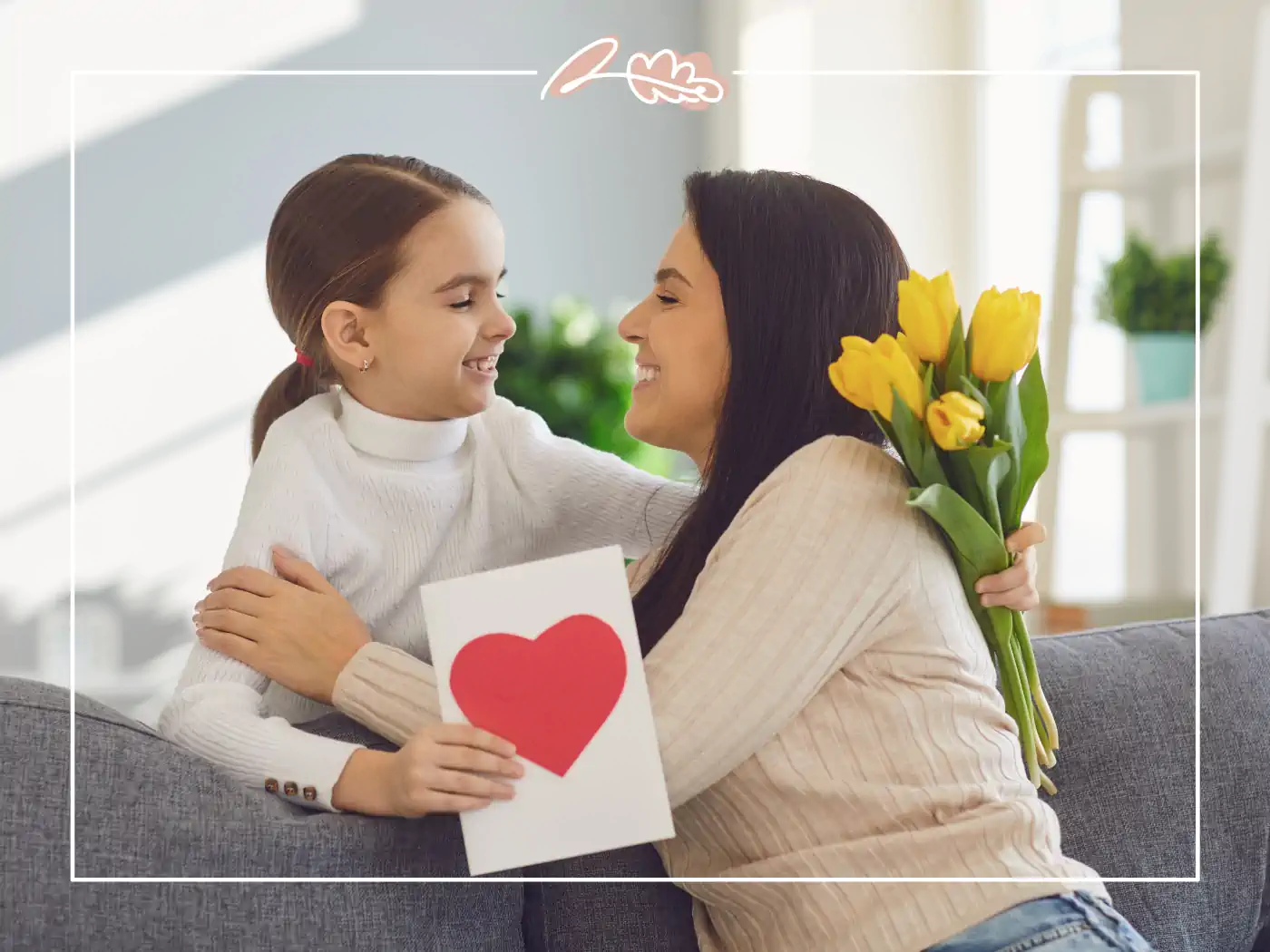 A mother and daughter sharing a hug with a bouquet of yellow tulips and a heart-shaped card. Fabulous Flowers and Gifts.
