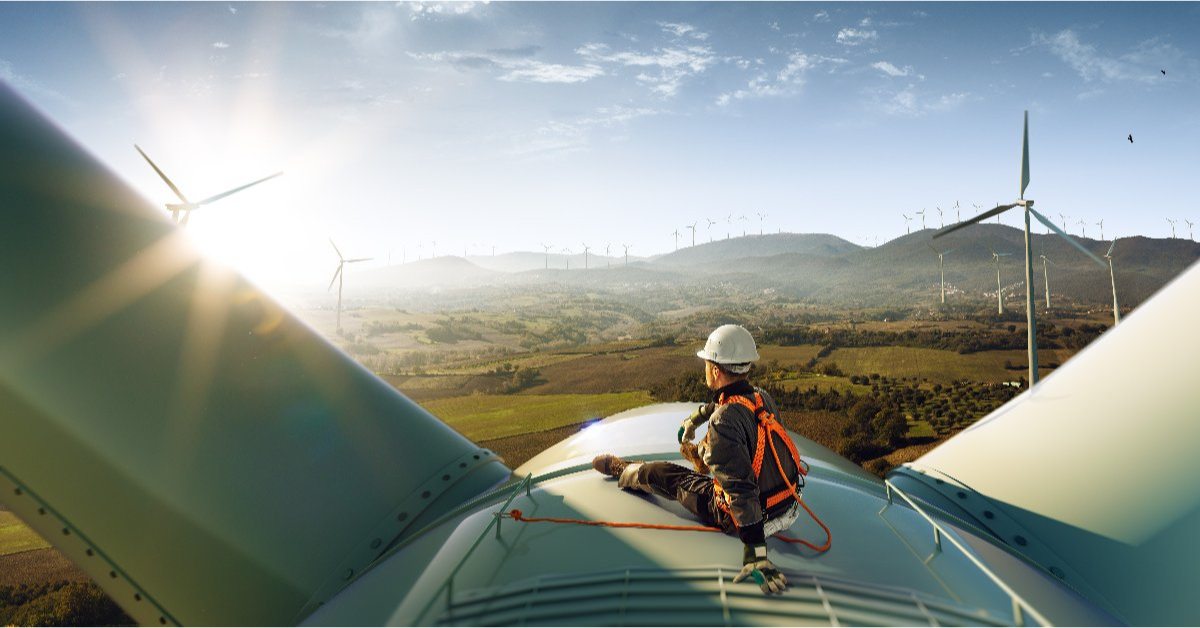 Is public utilities a good career path? Happy wind turbine technician sitting on a wind turbine