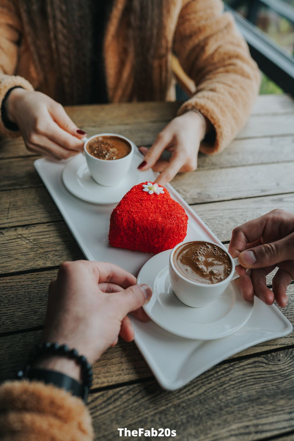 couple having coffee and heart shaped pastry - Featured In Article about Gemini and Scorpio compatibility 