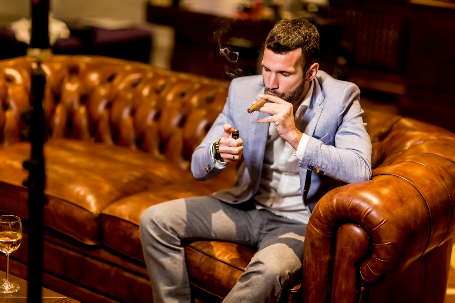 Cigar lounge with man lighting a cigar.