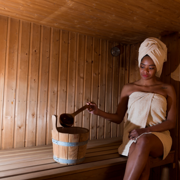 Image of a woman inside an outdoor sauna from her successful outdoor sauna project.