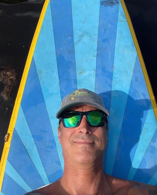 man lying on paddle board deck pad