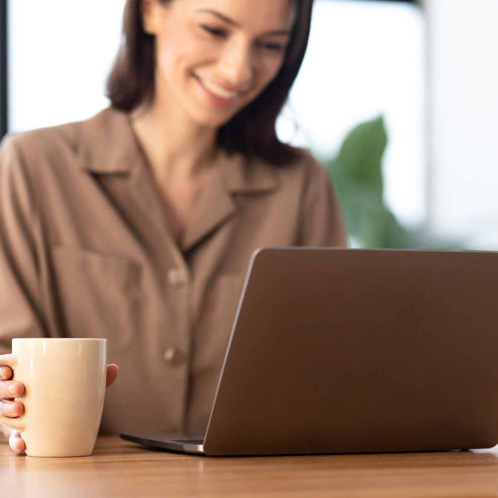 An image showing a person typing on a laptop with a cup of coffee on the side, illustrating how to make money online through engaging content creation.