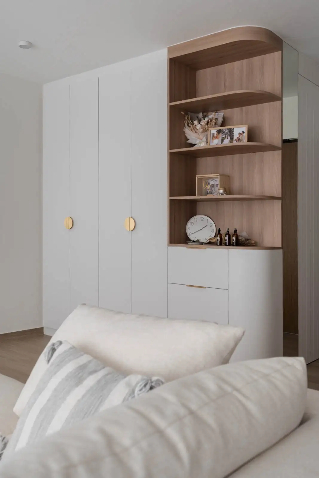 Minimalist interior design bedroom with curved wardrobe, open shelves and neutral textiles
