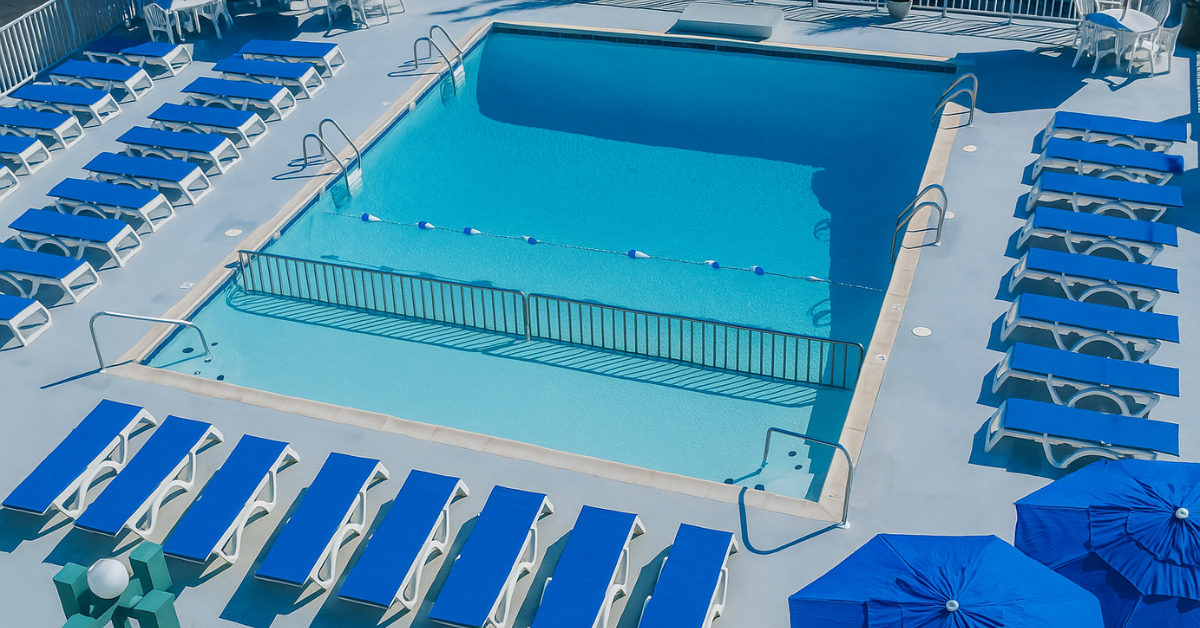 Bright blue pool surrounded by lounge chairs and umbrellas at the Diplomat Beach Club in Wildwood NJ.