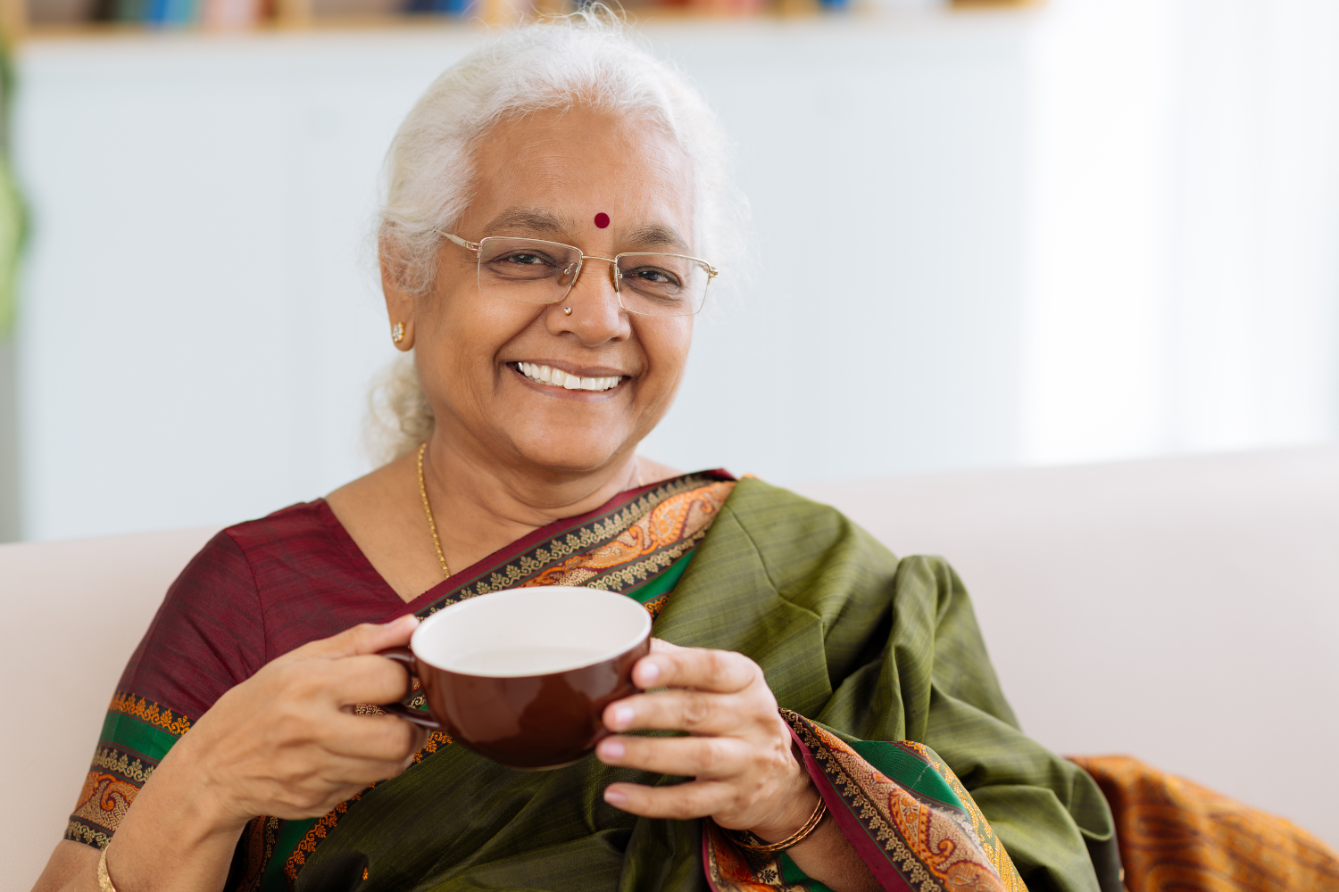 An old woman drinking tea, wearing the karnataka traditional dress, Ilkal saree.