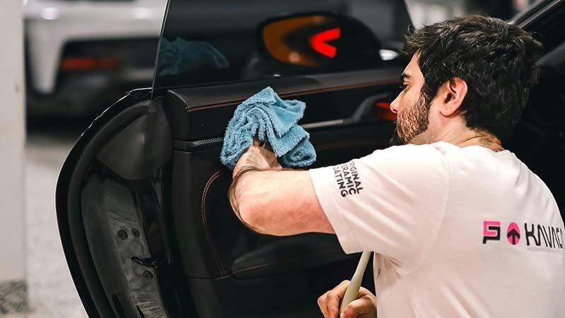 A man cleaning the inside of a car door