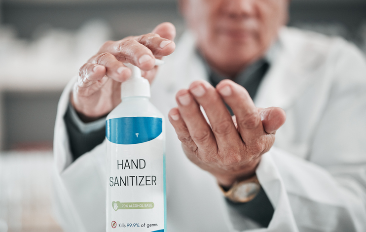 An image of a doctor using hand sanitizer. 