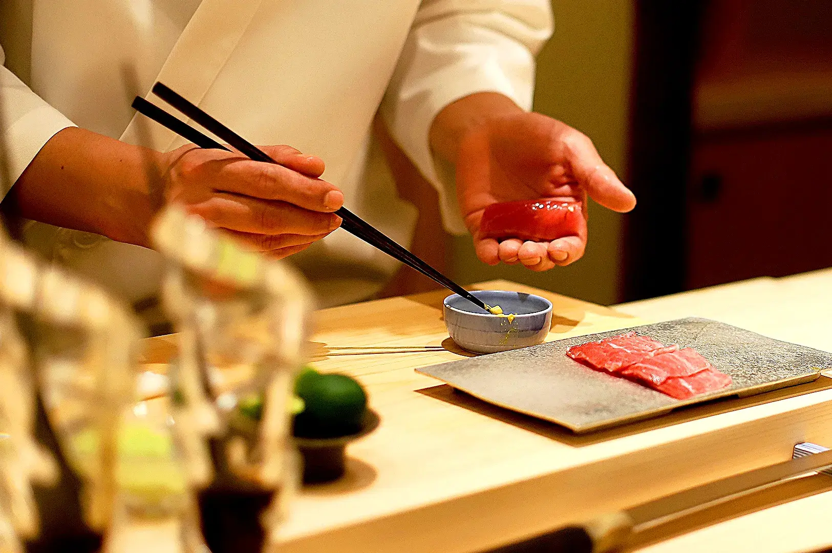 Sushi chef preparing fresh Japanese sushi at Sushi Sakuta Millenia Walk Singapore with premium seafood and traditional techniques