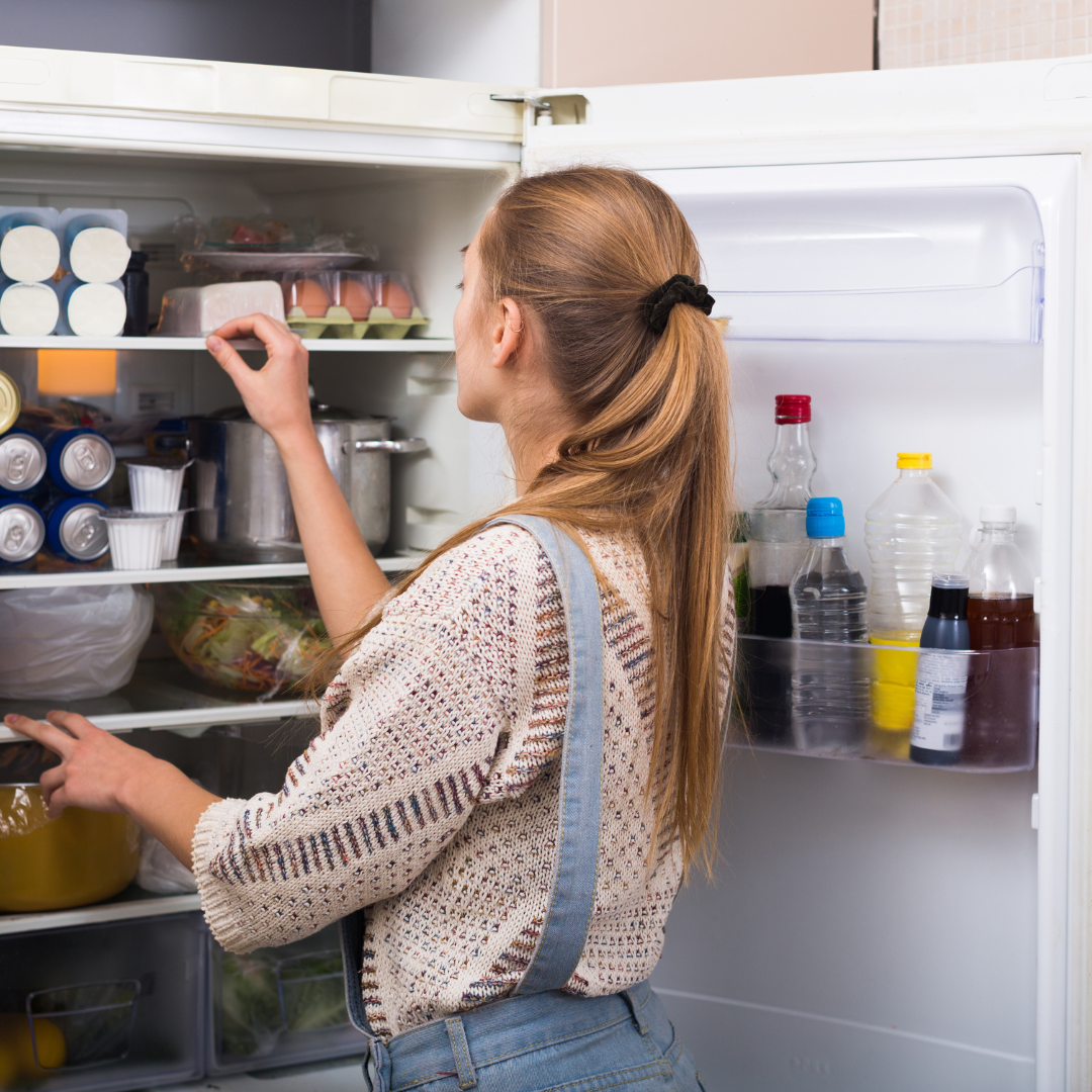 woman rearranging her fridge