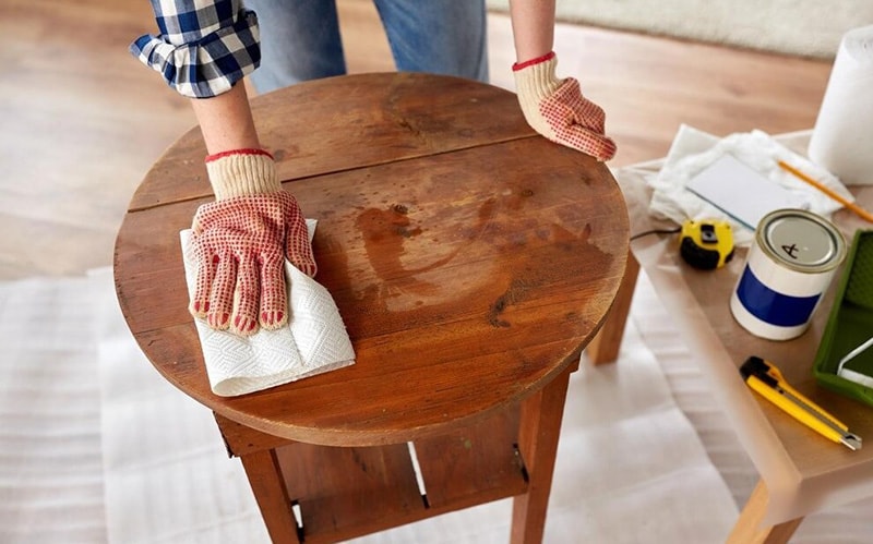 Women applying wax to the coffee table
