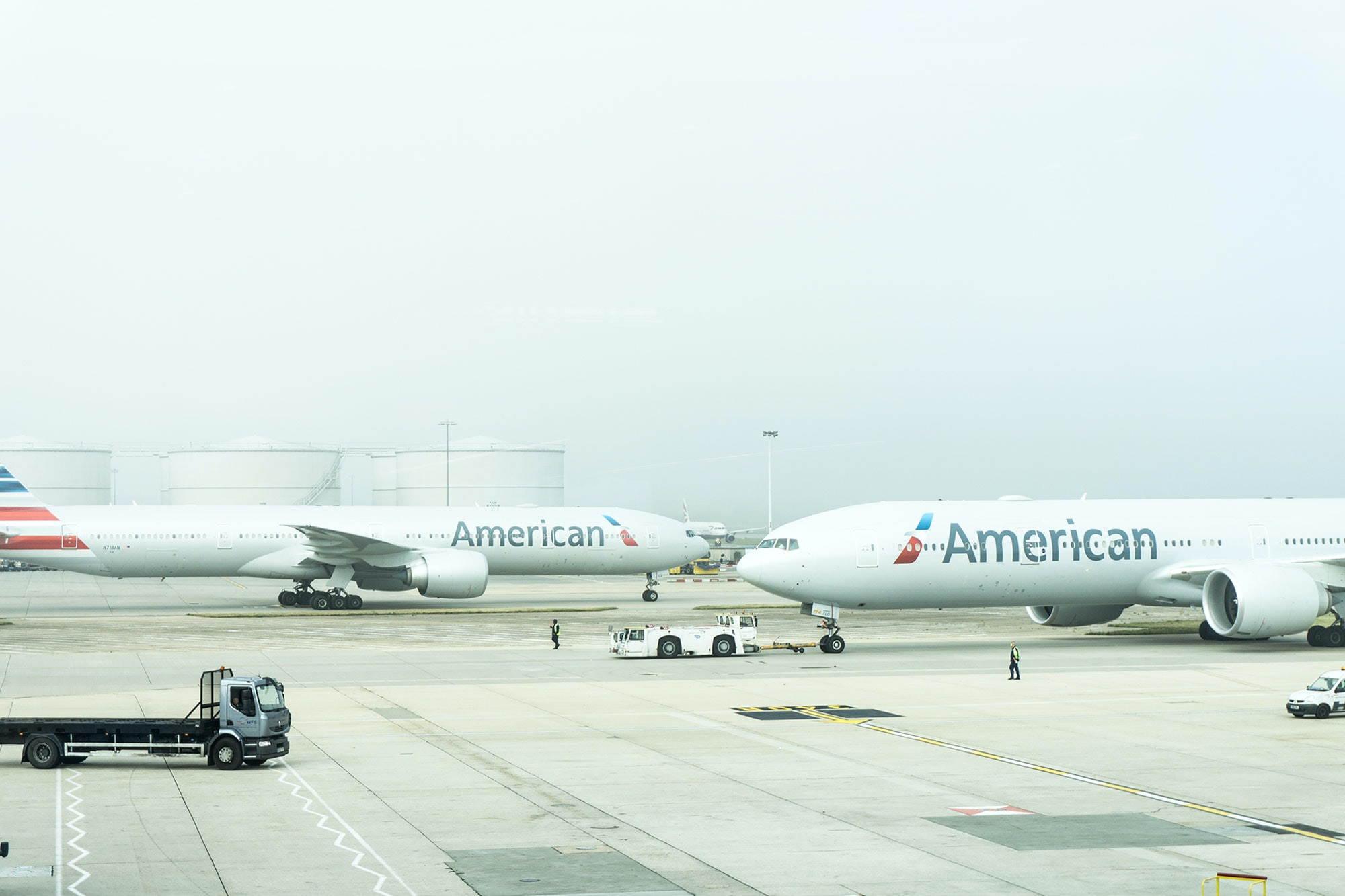 Two American Airlines aircraft taxiing around an airport tarmac.