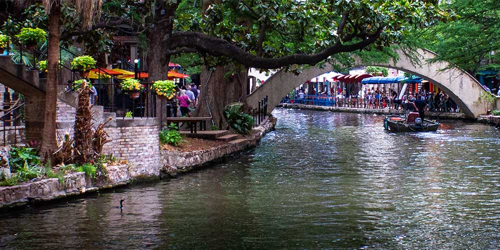 A view of the San Antonio Riverwalk with restaurants and outdoor seating