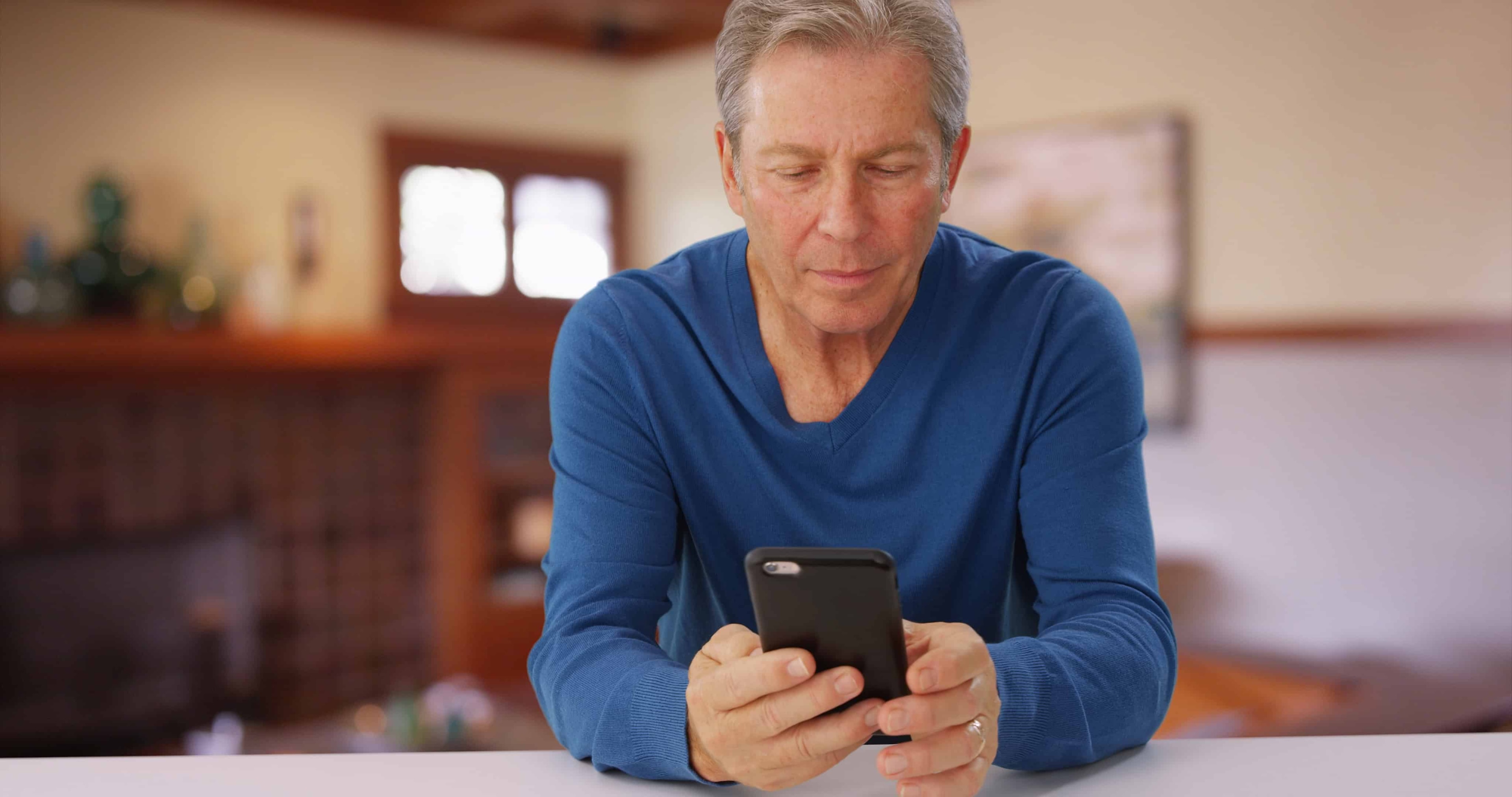 A man on his phone working all while doing a million other things.