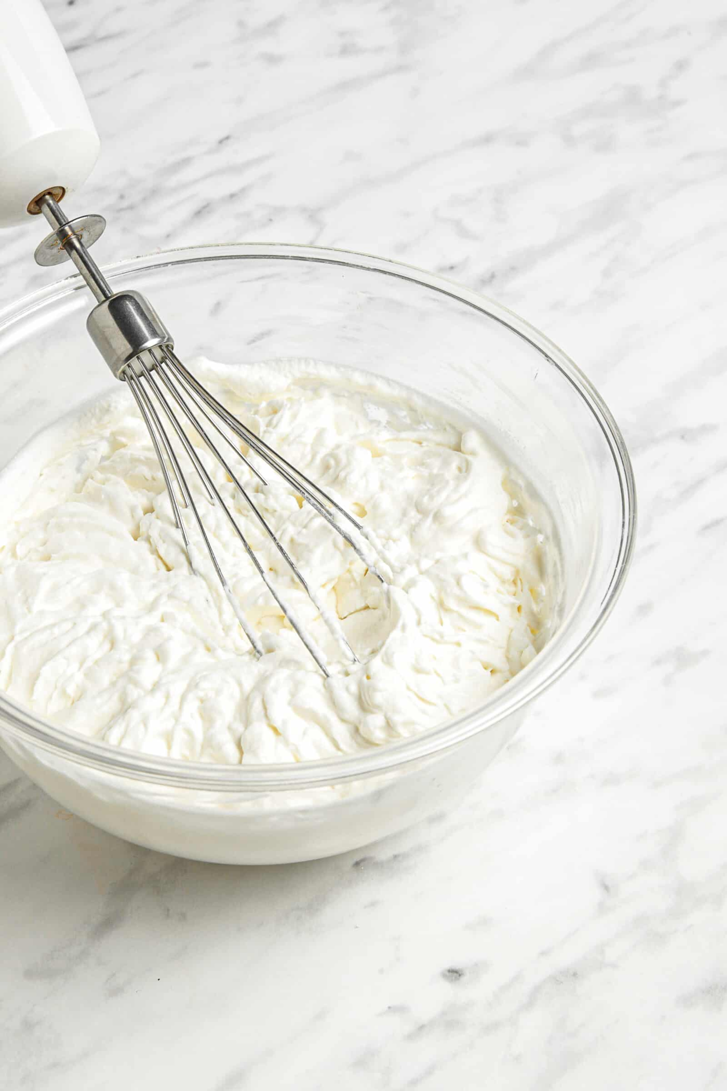 electric whisk in a bowl of whipped cream