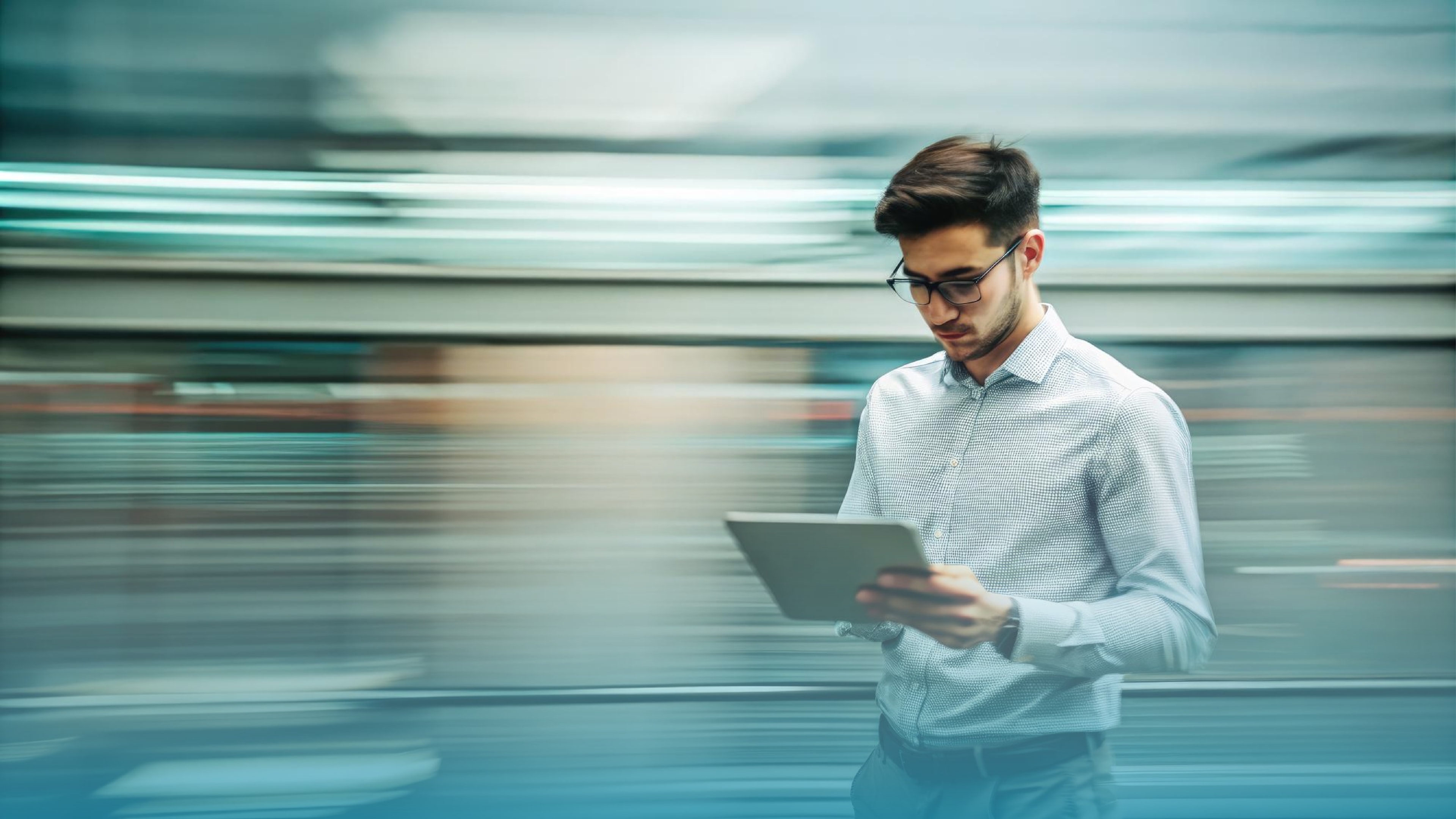 Young man walking while focused on a tablet, representing professional installation and the reliability of a tailored fiber internet solution.