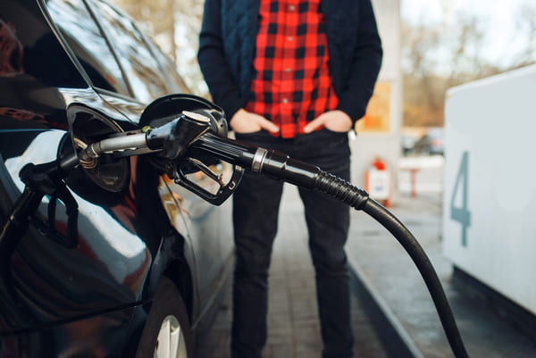 Person refueling car at gas station