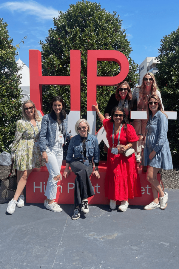 a group of designers in front of High Point Market signs