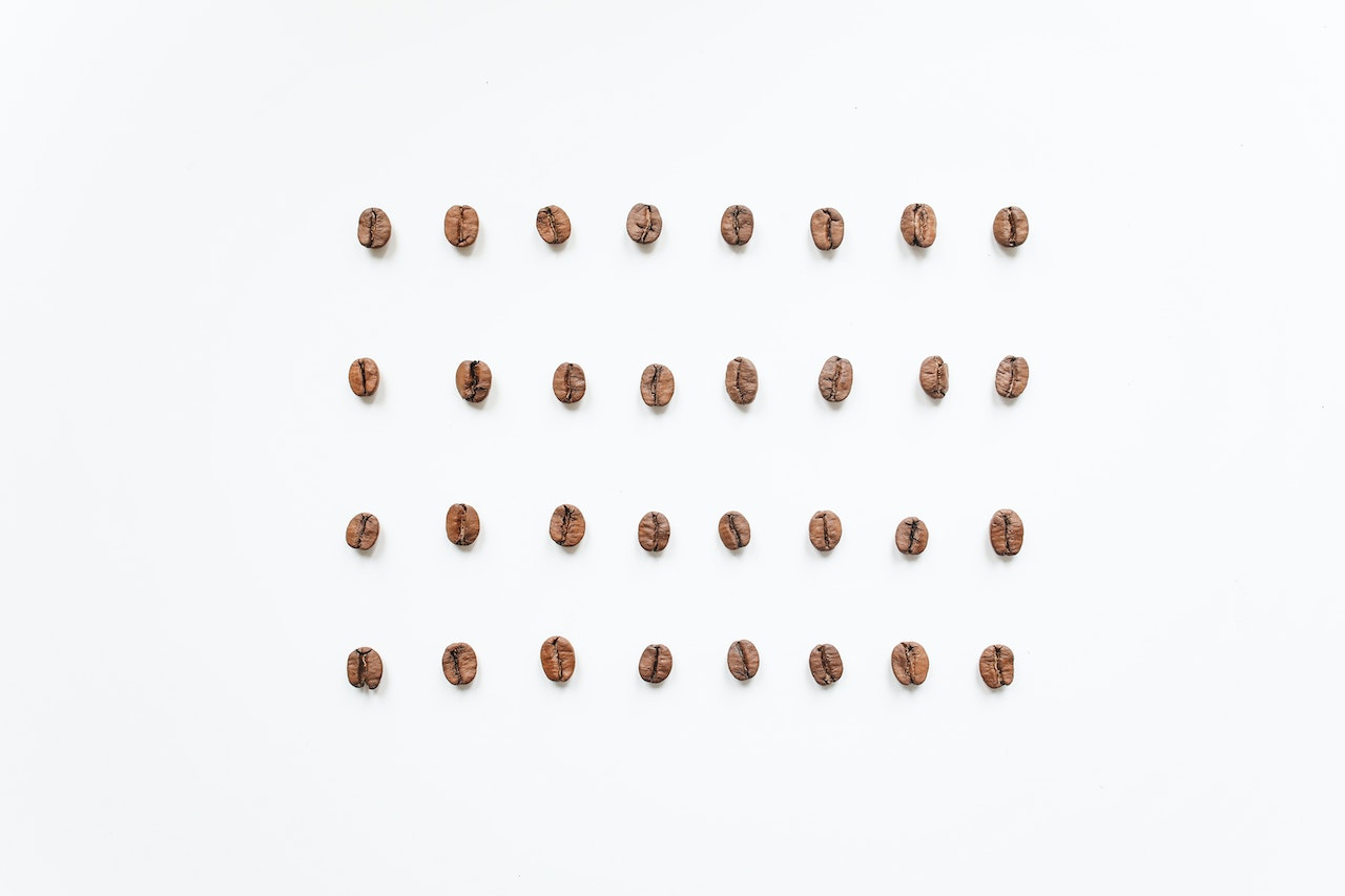 Grãos de café organizados em fileira, formando um quadrado. Fonte: Pexels